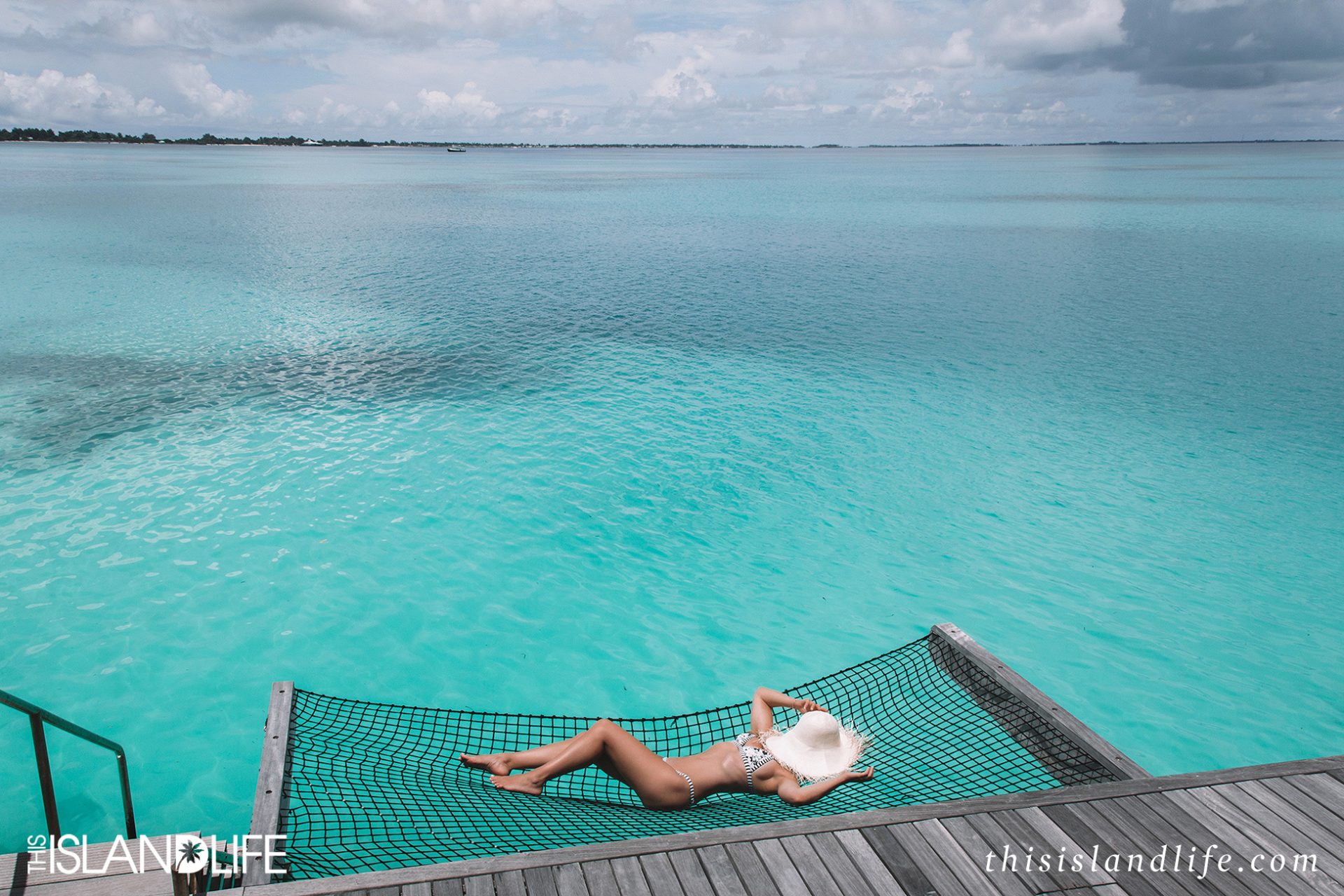 Girl in bikini at overwater villa in the Maldives 