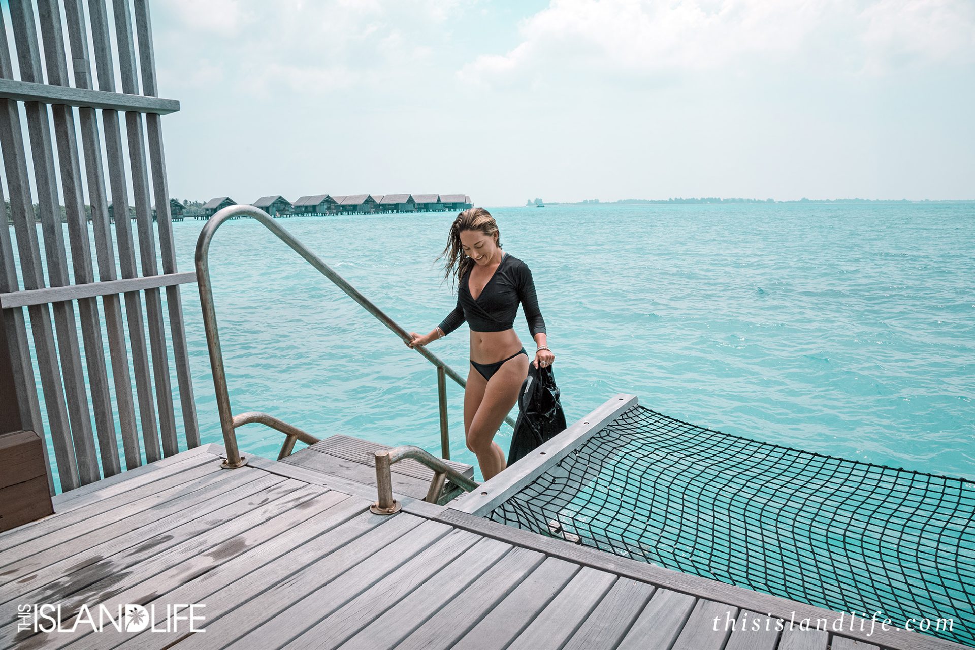 Girl in bikini at overwater villa in the Maldives 