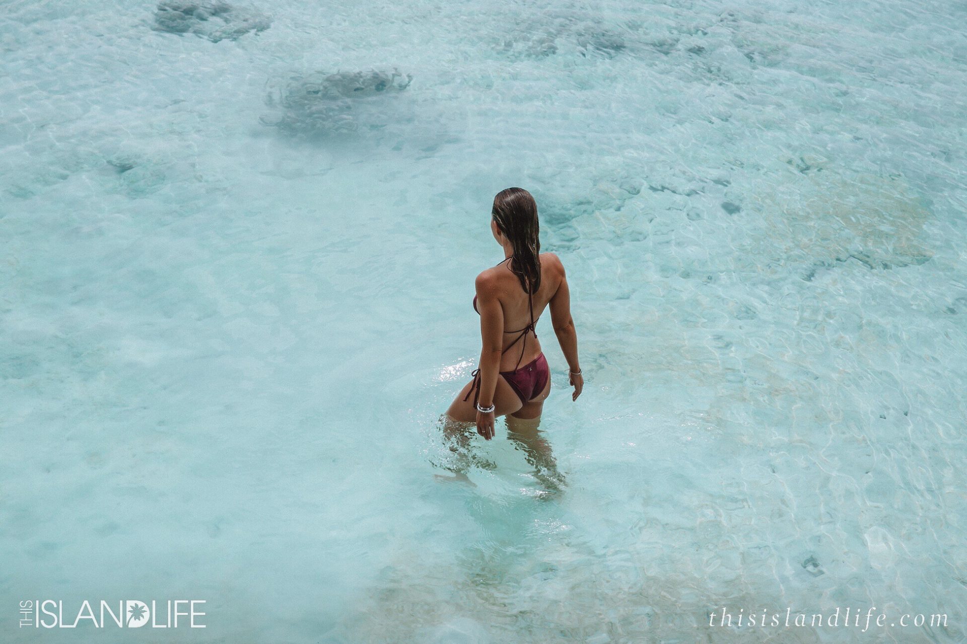 Bikini model swimming in clear aqua water